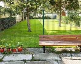 Un panneau Eco MRT dans un jardin privé avec des arbres