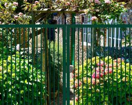 Puerta batiente Rondo de dos hojas instalada en un jardín