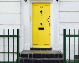 Verja Tubo Pasante Plus en la entrada de una casa con puerta amarilla